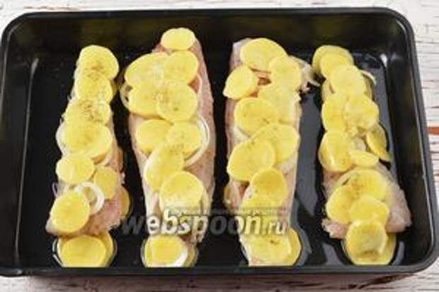 На лук выложить полосками кружочки картофеля. Эти кружочки должны быть очень тонкими (1-2 мм). Посыпать картофель оставшейся солью и чёрным молотым перцем. Готовить в предварительно разогретой до 170°C духовке приблизительно 35-40 минут (попробовать готовность картофеля). 